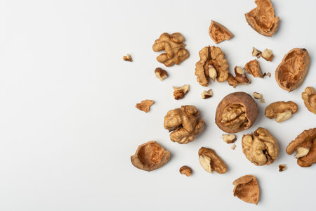 Walnuts and shells on white background. Natural healthy food concept emphasizing organic simplicity,...