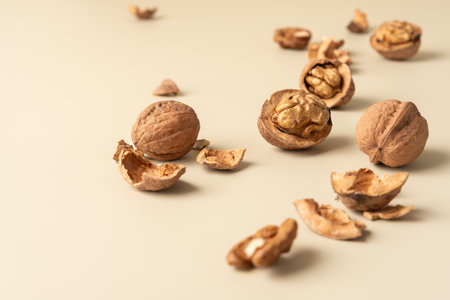 Close-up of walnuts and shells on neutral background. Natural healthy food concept emphasizing...