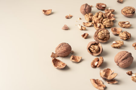 Close-up of walnuts and shells on neutral background. Natural healthy food concept emphasizing...