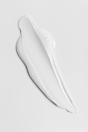 Transparent skincare gel smear on white background. Clean minimal beauty texture concept symbolizing purity, hydration and modern cosmetic design.の写真素材