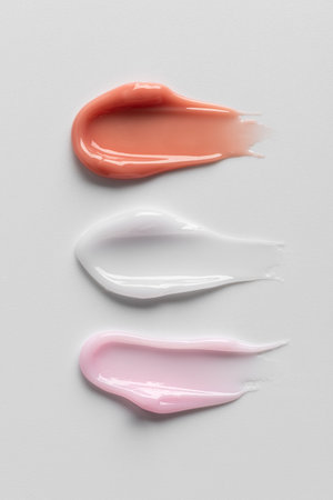 Beige and pink glossy cosmetic smears texture on clean background. Minimal beauty treatment concept for selfcare and wellness.の写真素材