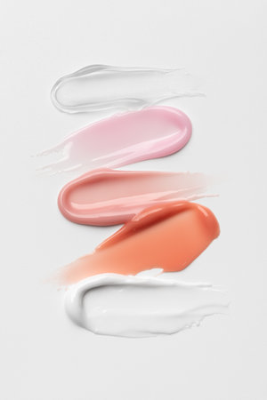 Beige and pink glossy cosmetic smears texture on clean background. Minimal beauty treatment concept for selfcare and wellness.の写真素材