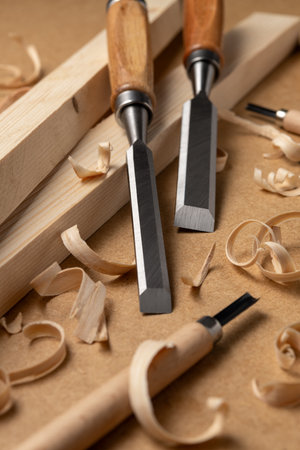 Woodworking chisels with fresh shavings on a workbench. Concept of craftsmanship, skill, slow craft, mastery, and the revival of traditional handmade woodworking techniques.の写真素材