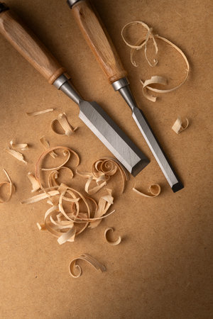 Woodworking chisels with curled wood shavings on a textured board. A detailed artisan craft scene...