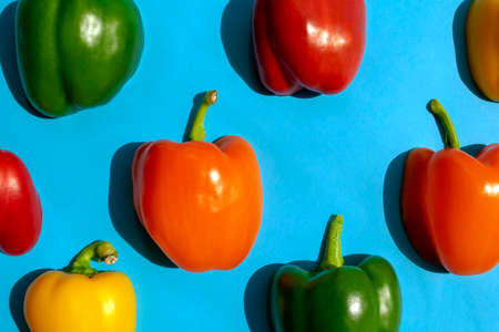 Bell peppers colorful pattern on bright blue background. Top view. Bell pepper flat lay. Different colors capsicum wallpaperの写真素材