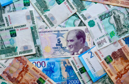 Turkish lira banknotes on top of russian national currency, top view of mixed rouble banknotes....