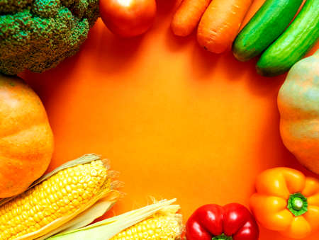 Frame of fresh vegetables with space for text on orange background. Copy space. Harvest festival. Happy Thanksgiving day background. Assortment vegetablesの写真素材