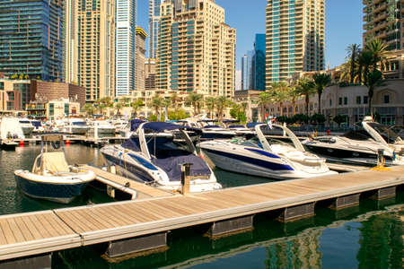 Dubai / UAE - November 7, 2019: Dubai Marina district with beautiful buildings and yachts. Dubai Marina yachts parking with concrete dock.のeditorial素材