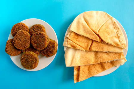 Famous traditional Arabic, Middle Eastern, Israel cuisine. Pita bread and falafel on blue...