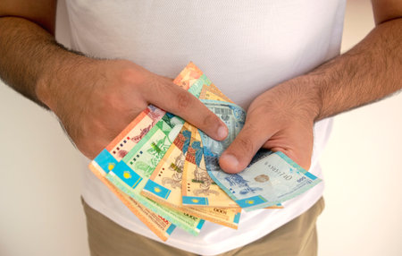 Kazakhstan national currency. KZ money banknotes. Man in white t shirt  holds tenge banknotes in his hands. Young man holds kz paper money.の写真素材