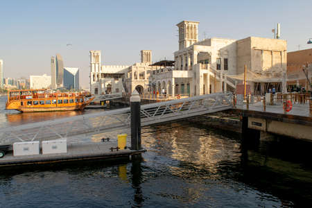 Dubai / UAE - February 21, 2020: Al Seef Village at Bur Dubai. Al Seef old style area with people. Wooden piers with big dhow boat.のeditorial素材