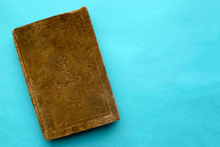Very Old Gospel in Old Slavonic language were published in 1915. Vintage damaged Holy Russian Christian book on blue background with copy space.の写真素材