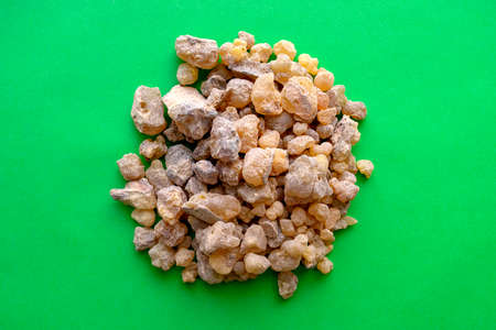 Frankincense heap on green background. Incense or Olibanum aroma resin isolated on green.の写真素材