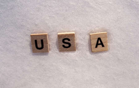 USA word on a white clean snow. USA country is written on a snow with wooden letters.の写真素材