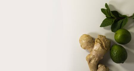 Tea supplement ginger root, peppermint leaves and lime fruit. Copy space.