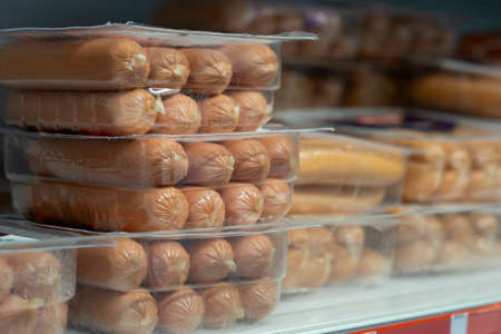 Raw sausages in packages on shelves in a retail storeの写真素材