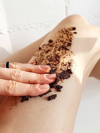 Girls legs close-up with coffee scrub. Spa, beauty treatments, relaxation. Restoring skin elasticity. High quality photoの写真素材