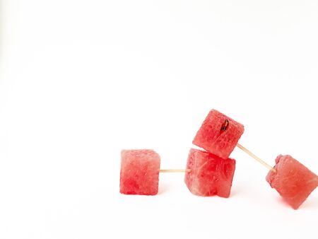 Bright ripe juicy red watermelon squares on a white background. Space for text. High quality photoの写真素材