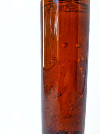 Air bubbles in a brown liquid bottle on a white background with space for brand text. High quality photoの写真素材
