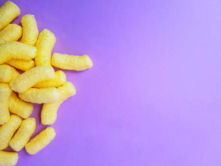 Yellow corn sticks on a purple background. High quality photo
