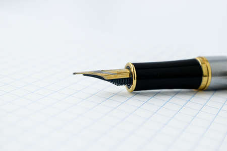 Feather pen on a white sheet of paper in a cage. High quality photoの写真素材