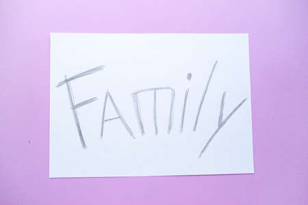 The text of the family on a white sheet of paper in a cage on a purple background. Destruction and divorce. Step by step. Family security. High quality photoの写真素材