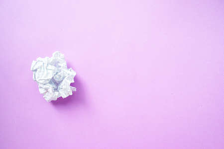 A crumpled sheet of white paper in a cage on a purple background. High quality photo