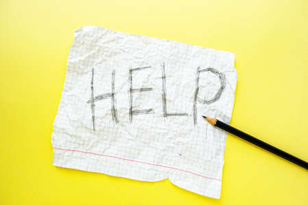 Text help on a white sheet of notebook in a cage on a bright yellow background. Step by step. High...