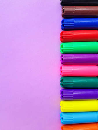 Multicolored markers on a purple background. Drawing. Back to school. . High quality photo