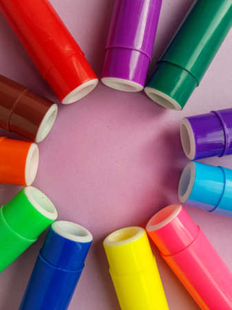 Multicolored markers on a purple background. Drawing. Back to school. . High quality photo