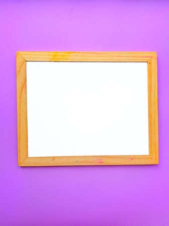White empty clean school board on a purple background with a wooden brown frame. Back to school. Mochup. High quality photoの写真素材