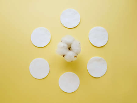 Cotton cotton discs on a yellow background. Personal hygiene and care. Medicine and cosmetology. High quality photoの写真素材