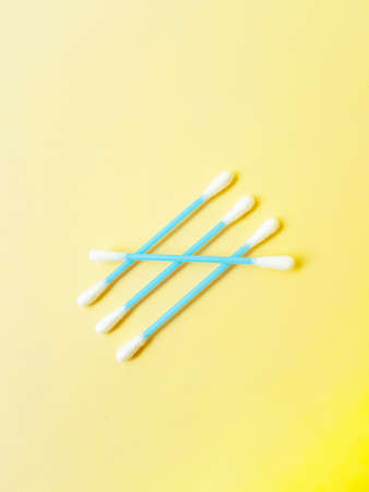 Ear cotton buds are blue on a yellow background. Cosmetology and medicine. Personal hygiene and...