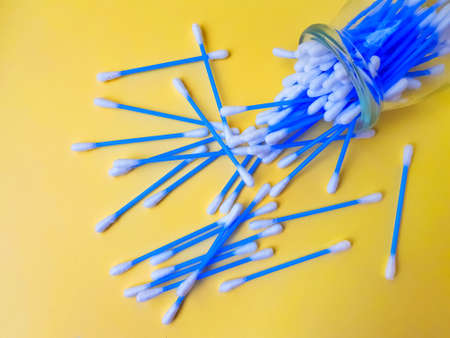 Cotton sticks ear blue plastic on a yellow background. Personal hygiene and care. Cosmetology and...