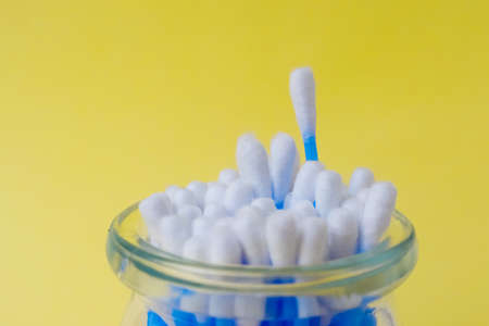 Cotton sticks ear blue plastic on a yellow background. Personal hygiene and care. Cosmetology and...