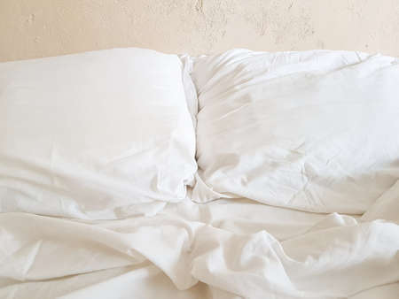 An unfilled bed after sleeping with white linen. Good morning. The concept of rest and relaxation....