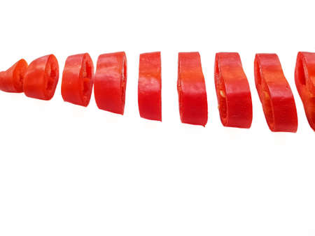 Red fresh pepper cut into equal parts of the ring on a white background. High quality photo