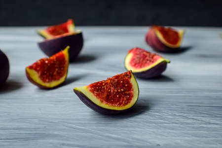 Bright ripe figs on the wooden surface at the back of a dark background. High quality photo