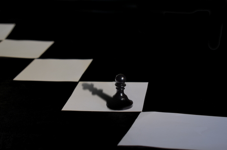 A chess pawn with a queen shadow. The concept of dreams and aspirations for development.