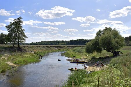 Sumy region, Ukraine, August, 2019. Tourists relax on the river during a lunch break.