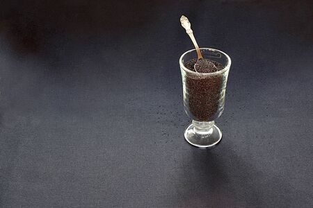 Amaranth seeds in a glass with a small spoon on a black background.の写真素材
