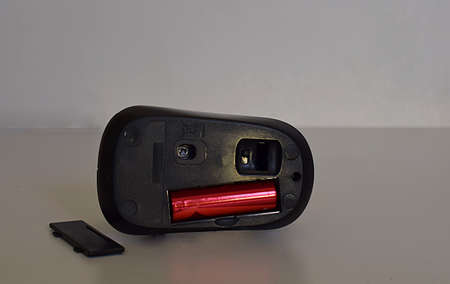 Black wireless computer mouse and battery inserted.