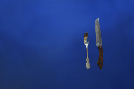 Cupronickel fork and knife on a blue background.の写真素材