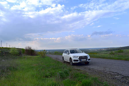 Donetsk region, Ukraine, May, 2019. White Audi car on a rural road. Landscape with an open horizon.のeditorial素材
