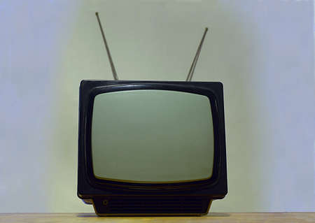 Old portable TV with antenna on a light background.の写真素材