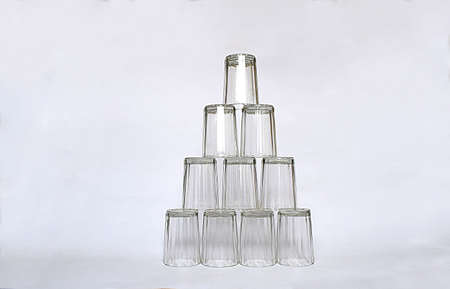 Ten faceted glasses placed upside down in a pyramid.の写真素材