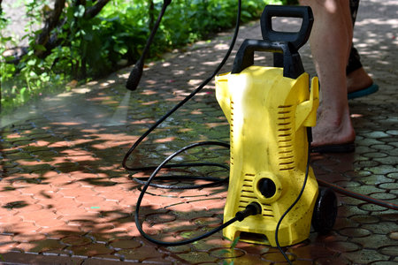 Cleaning paving slabs with a high pressure washer.の写真素材