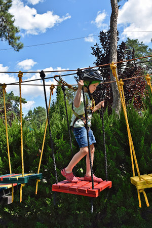 A boy concentrates on completing an obstacle course in a park.