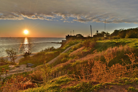 Sunrise over the sea, a steep shore illuminated by the morning sun.の写真素材