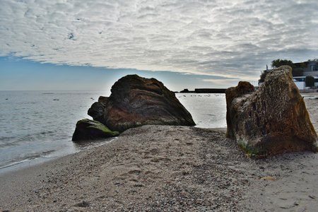 Large stones with an interesting structure on the sandy seashore.の写真素材